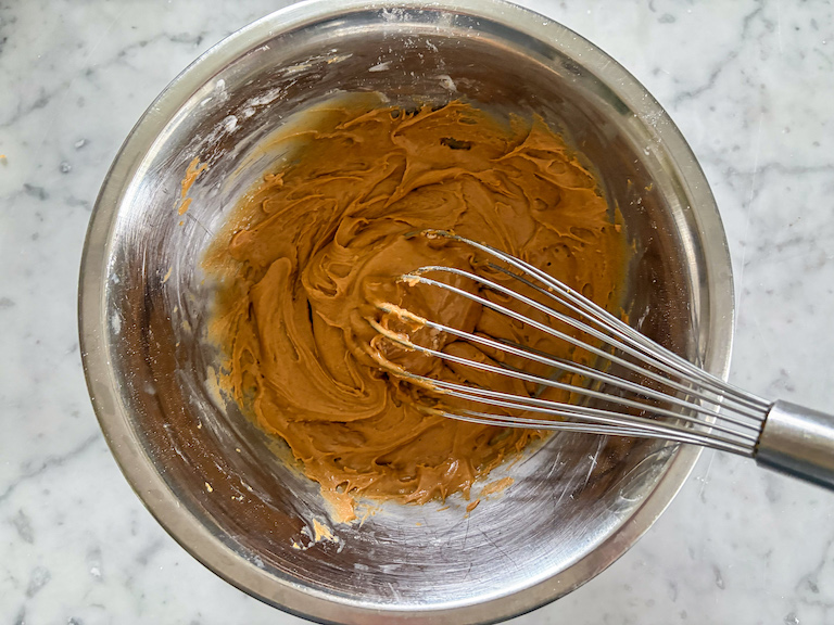 peanut butter in a metal bowl with a whisk