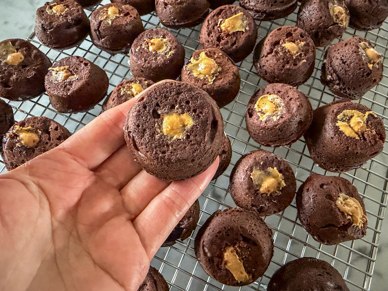Hand holding a chocolate peanut butter stuffed mini muffin