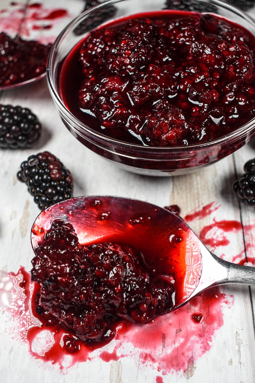 A dish and spoon of blackberry compote