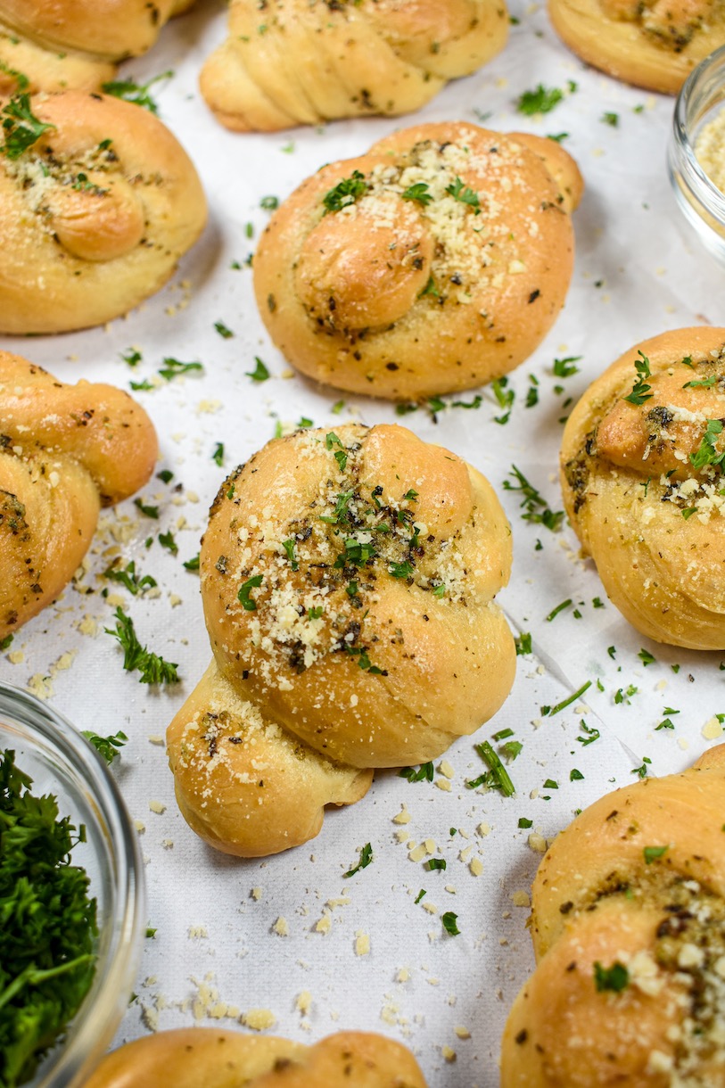 Homemade garlic knots arranged on a white surface