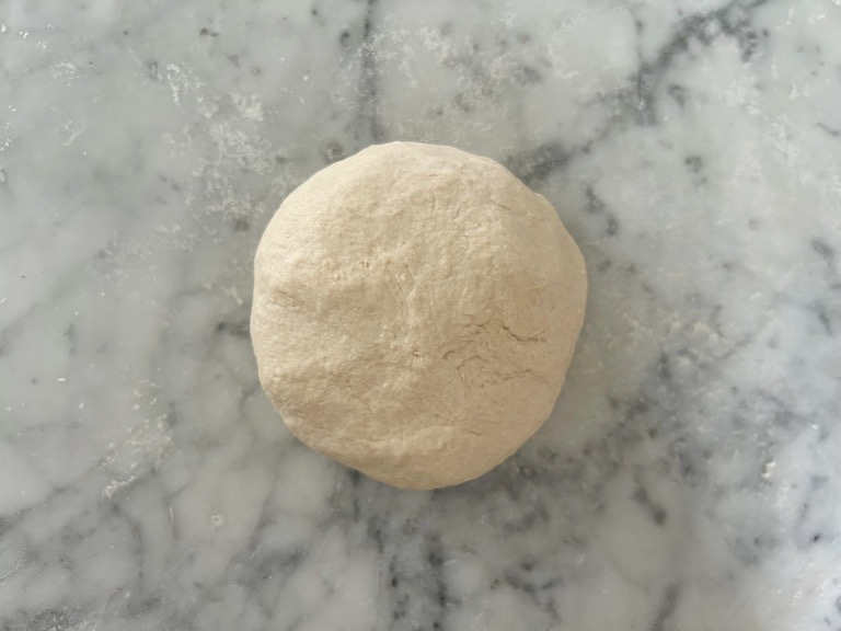 A ball of dough on a marble surface