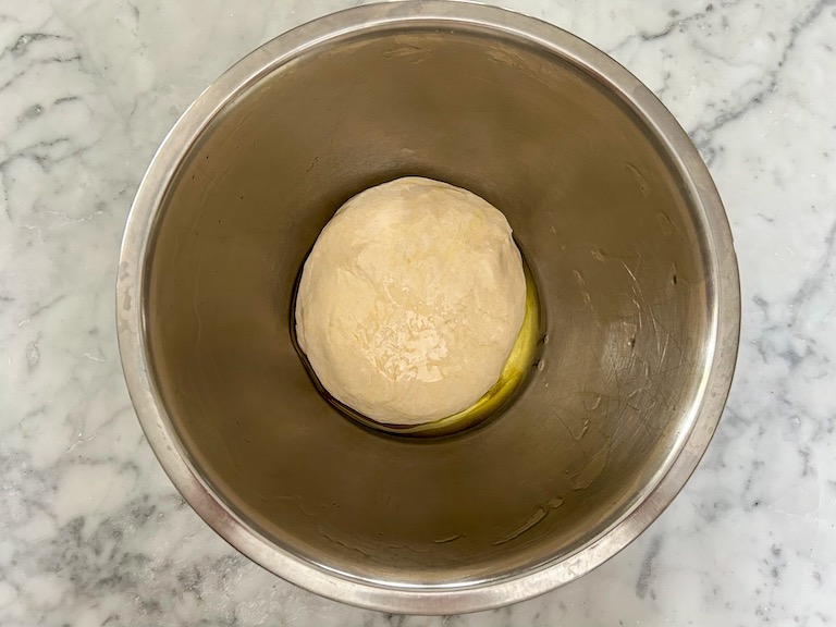Ball of dough in a bowl, drizzled with oil