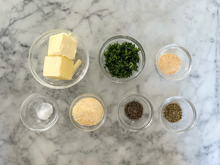 Garlic butter ingredients arranged on a marble surface