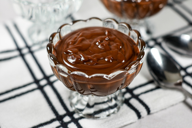 A dish of homemade hot fudge sauce on a plaid towel