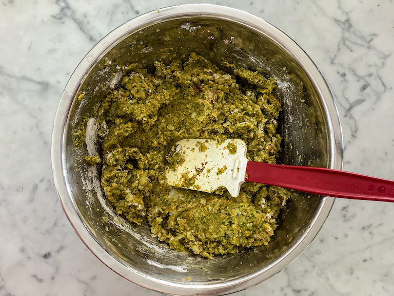 Veggie mash in a bowl with a rubber spatula