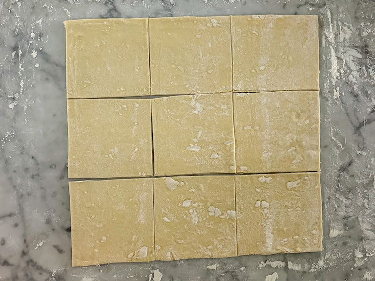 squares of puff pastry on marble work surface