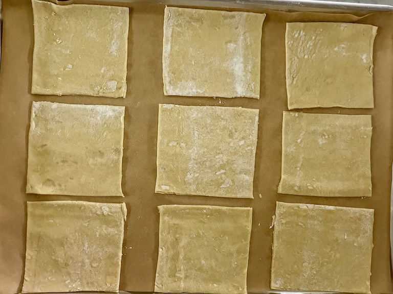 Squares of puff pastry on tray