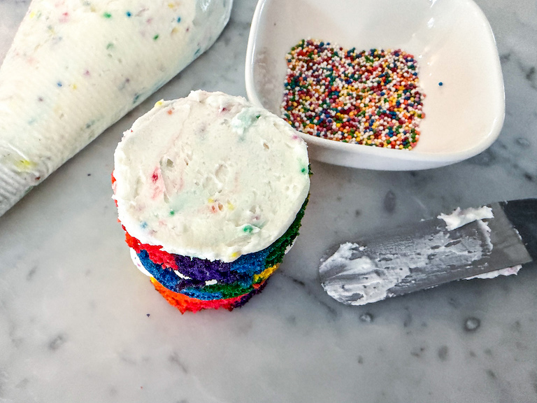 Palette knife spreading buttercream on a mini layer cake