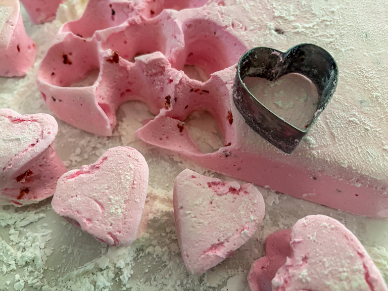 cutting heart shaped marshmallows with a metal cookie cutter