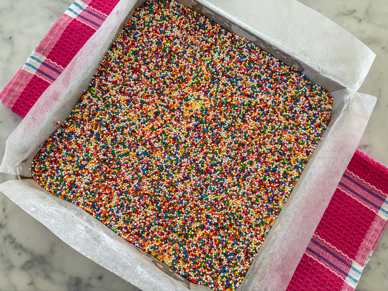 a pan of marshmallows covered in rainbow nonpareils
