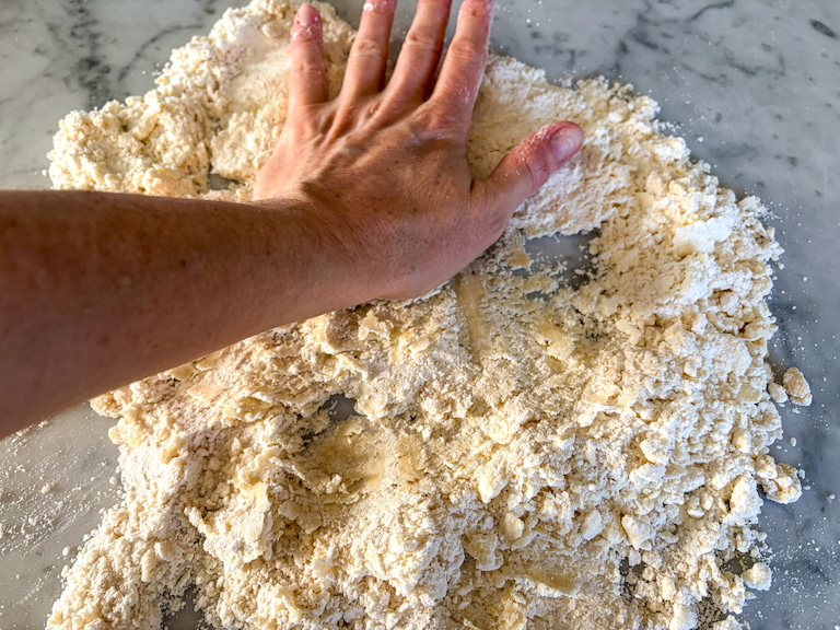 hand mixing pastry on a marble surface