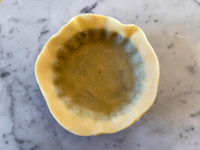 Lining a miniature tartlet shell with pastry