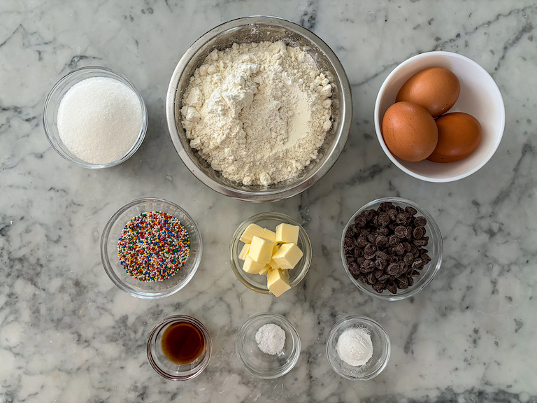 Dot biscotti ingredients arranged in dishes on a marble surface