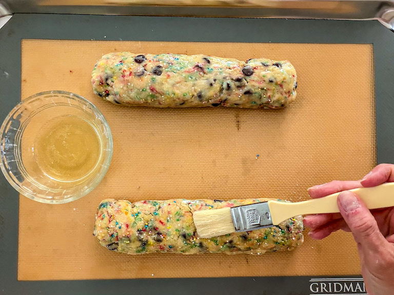 Hand brushing biscotti logs with egg white