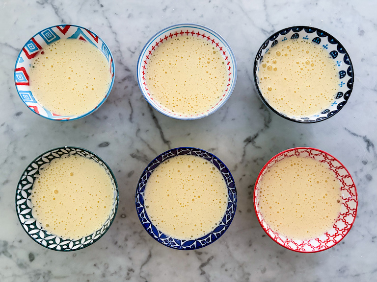 Six mini bowls of cake batter