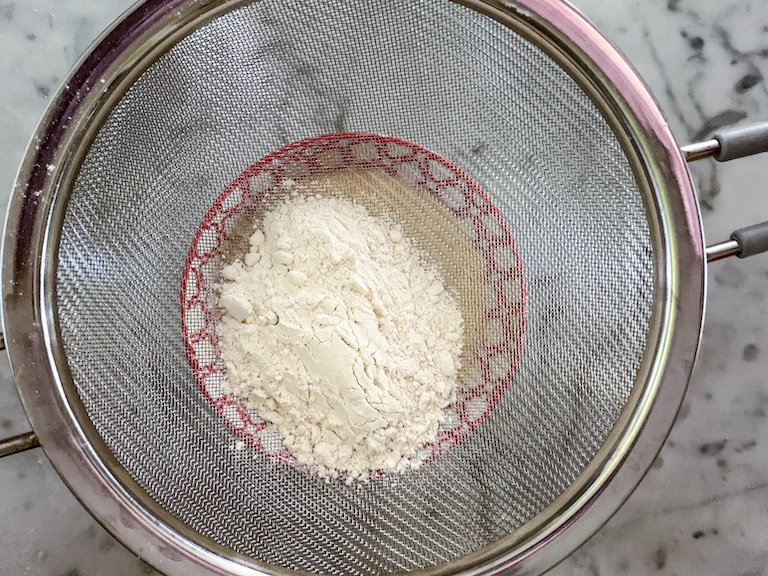 sifting flour into cake batter