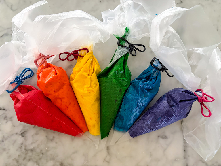 Piping bags of rainbow cake batter