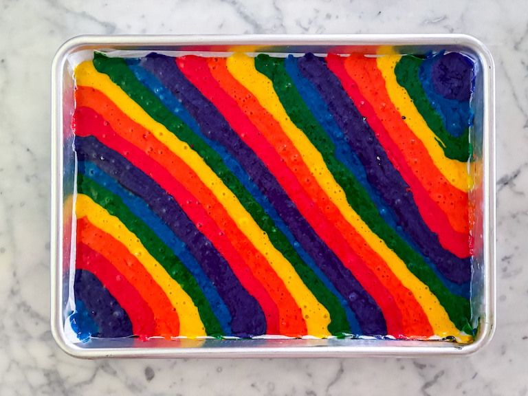 Rainbow cake batter piped on a small tray