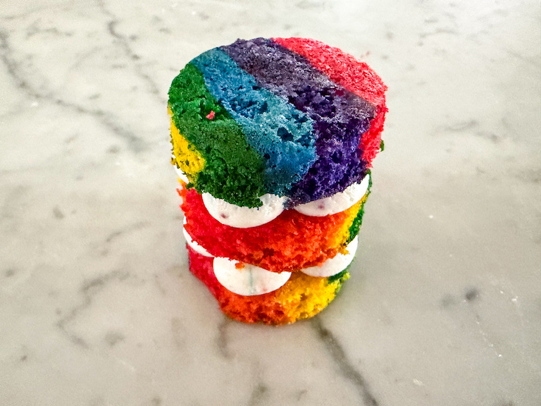 Assembling a mini rainbow layer cake