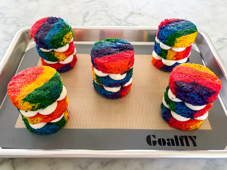 mini rainbow cakes arranged on a tray