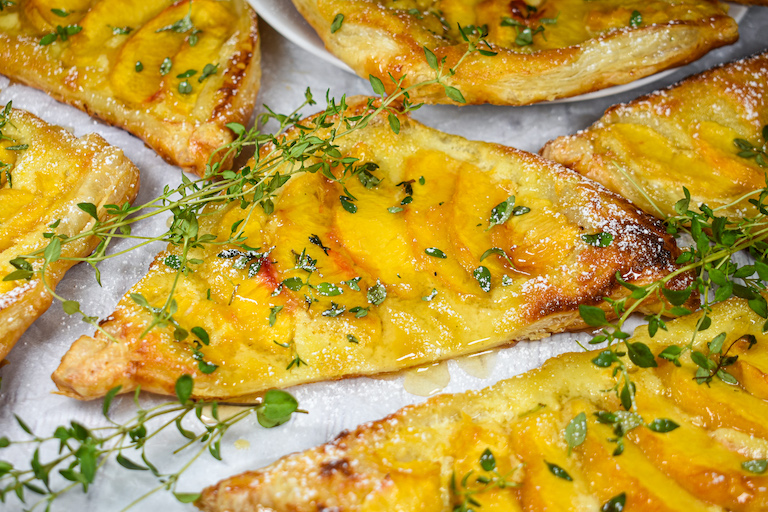 Triangle of puff pastry with mascarpone cheese, peaches, honey and thyme