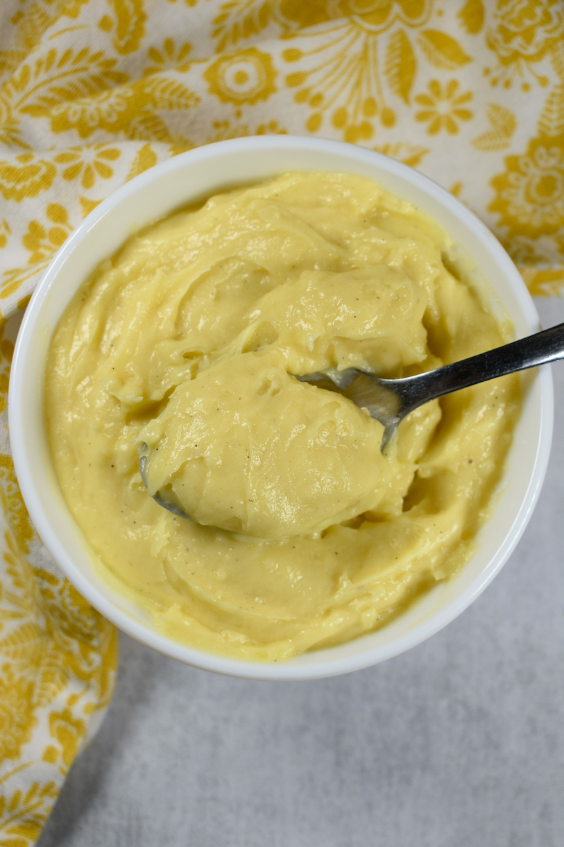 a bowl of homemade pastry cream with a spoon