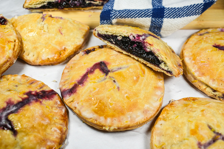blueberry hand pies arranged on a white surface