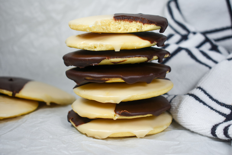 a stack of NYC-style black and white cookies on a white surface