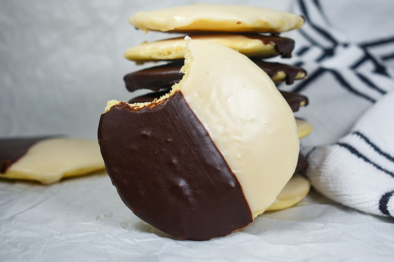 a new york style black and white cookie with a bite missing