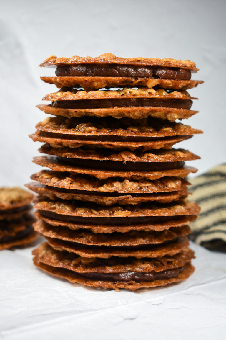 a stack of oatmeal lace cookies with chai chocolate ganache filling