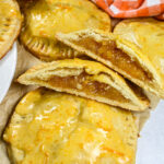 sliced peach hand pies on a sheet of brown parchment