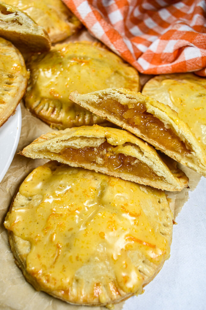 sliced peach hand pies on a sheet of brown parchment
