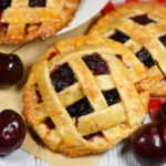 A recipe and instructions for making individually sized cherry pies with homemade pastry, a cherry apple filling, and a lattice top.