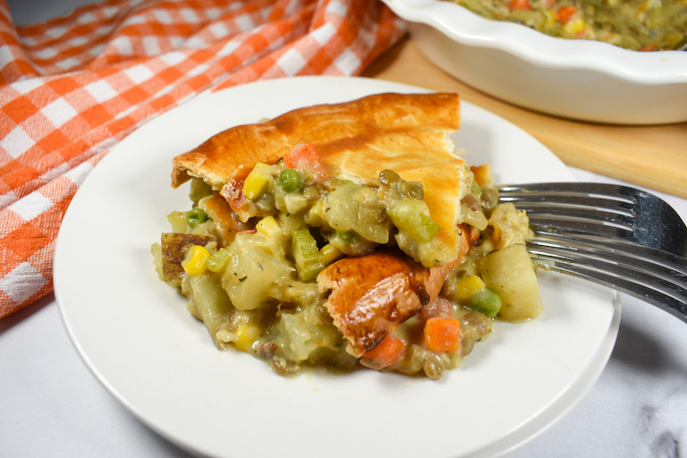 a slice of lentil pot pie on a white plate