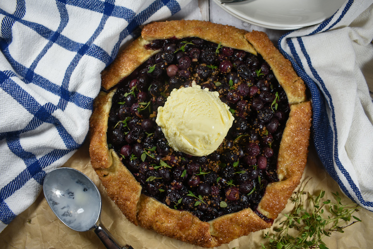 Blueberry galette garnished with a scoop of vanilla ice cream