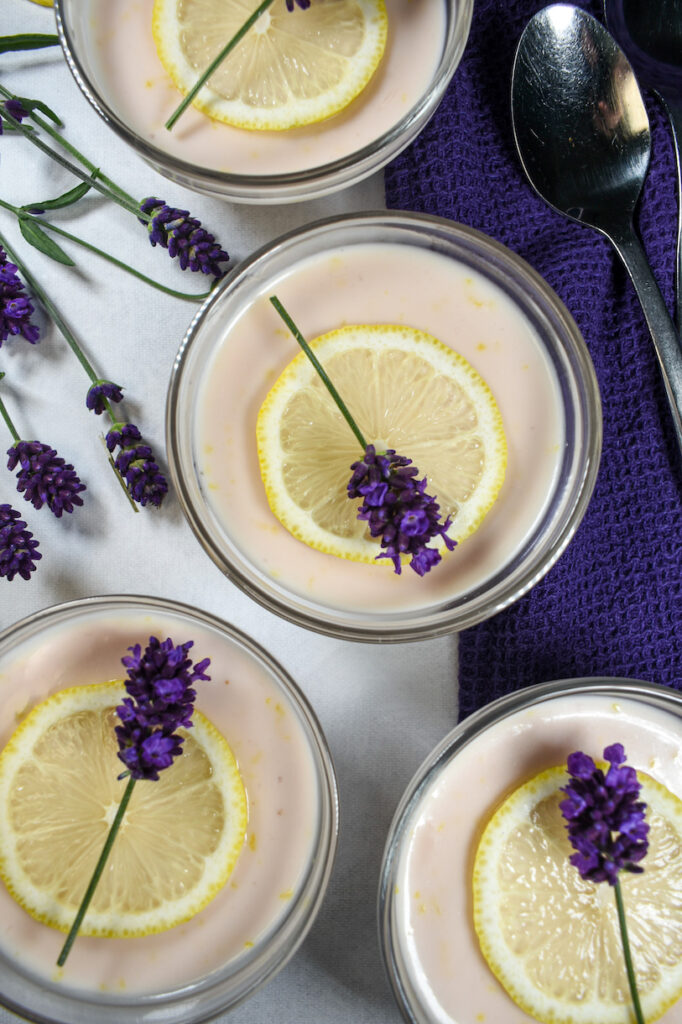 Lavender lemon possets garnished with lemon slices and fresh lavender flowers