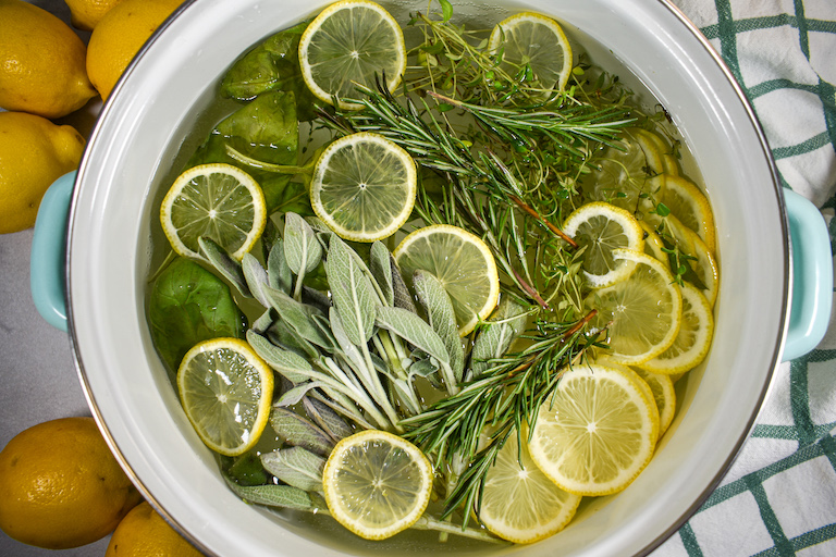 simmer pot with lemon slices and fresh herbs