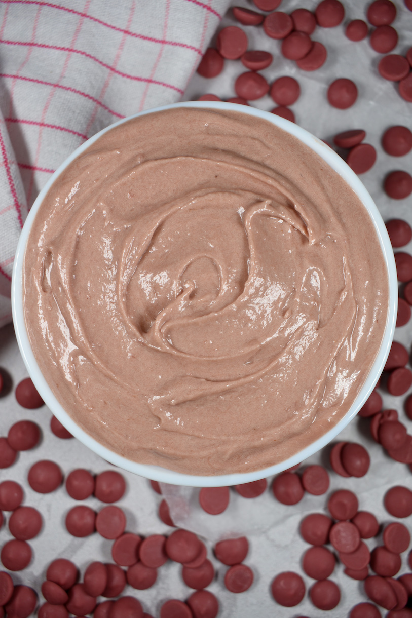 a bowl of ruby raspberry ganache surrounded by ruby chocolate callets