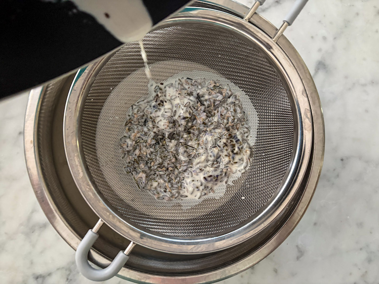 passing lavender cream through a fine mesh strainer