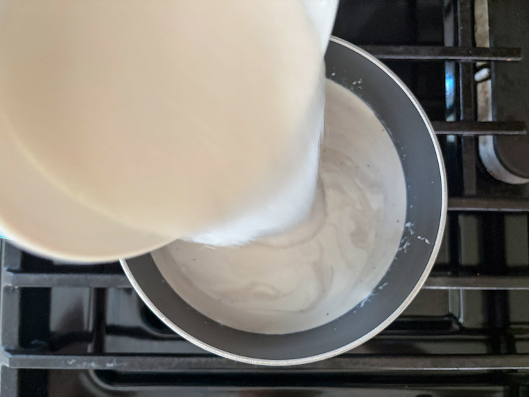 pouring granulated sugar into lavender infused cream