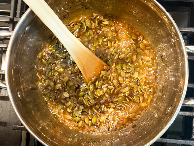 stirring pepitas into sugar syrup