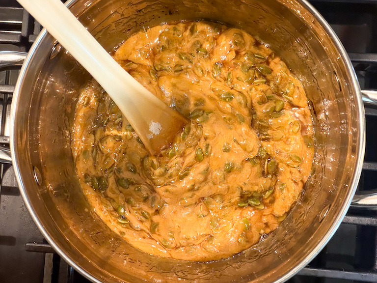 stirring baking soda into pumpkin seed brittle