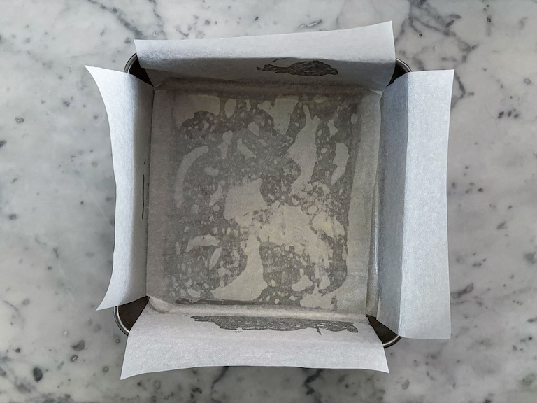 A square tin lined with baking parchment