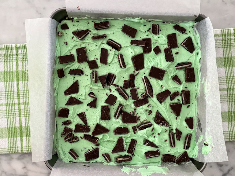A pan of chocolate mint brownies arranged on a green plaid towel
