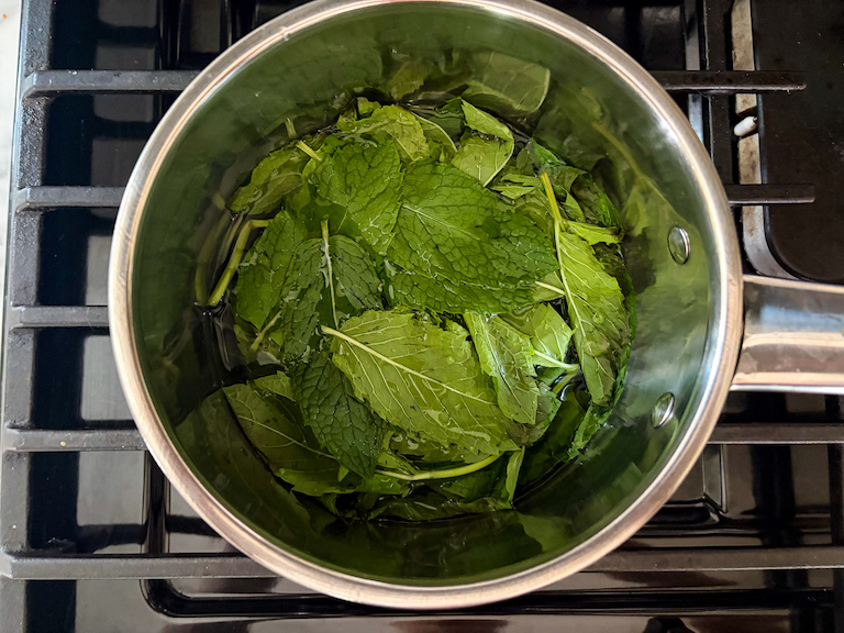 A pan of mint leaves on a stovetop