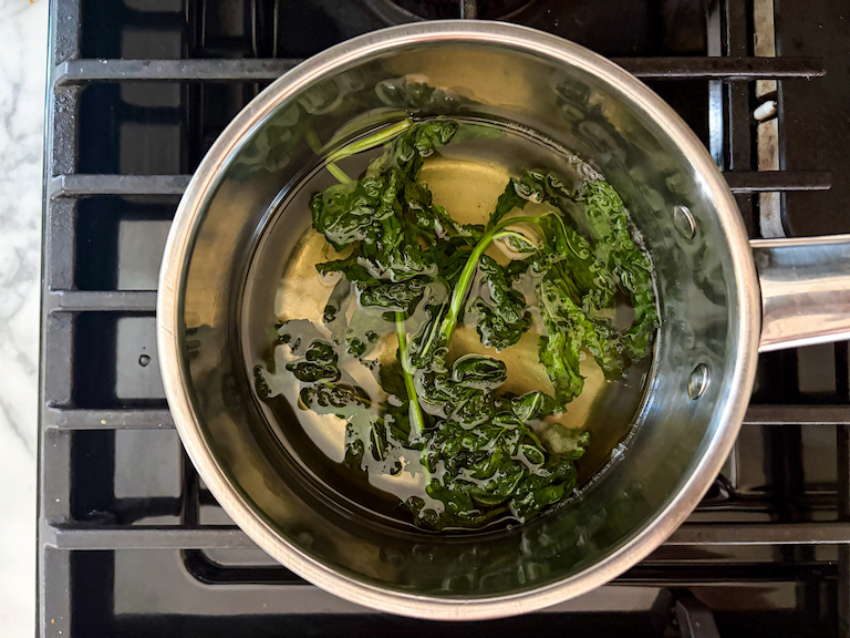 Simmering homemade mint syrup in a pan on the stovetop