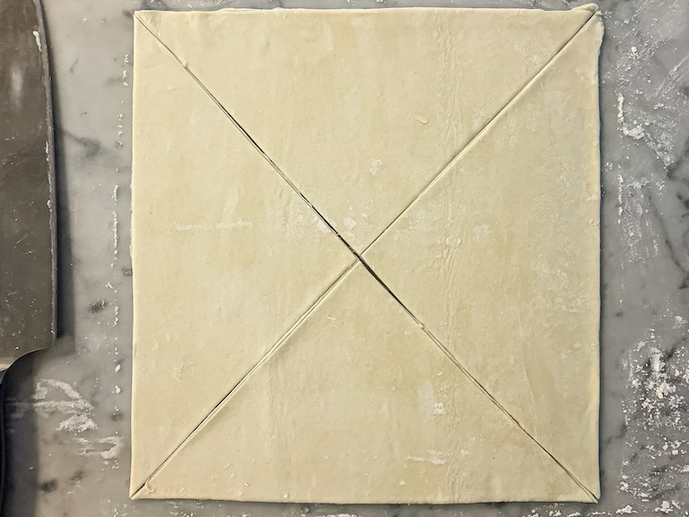 a square of puff pastry sliced into four triangles