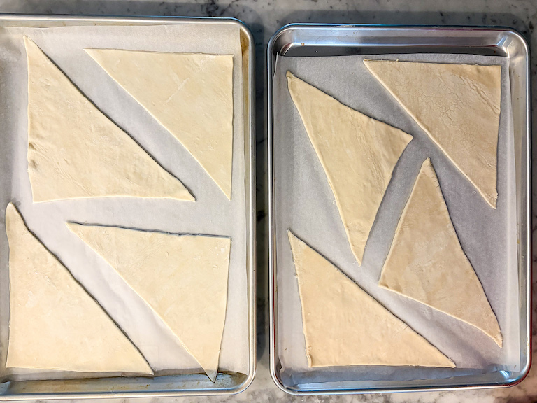 triangles of puff pastry arranged on two metal trays