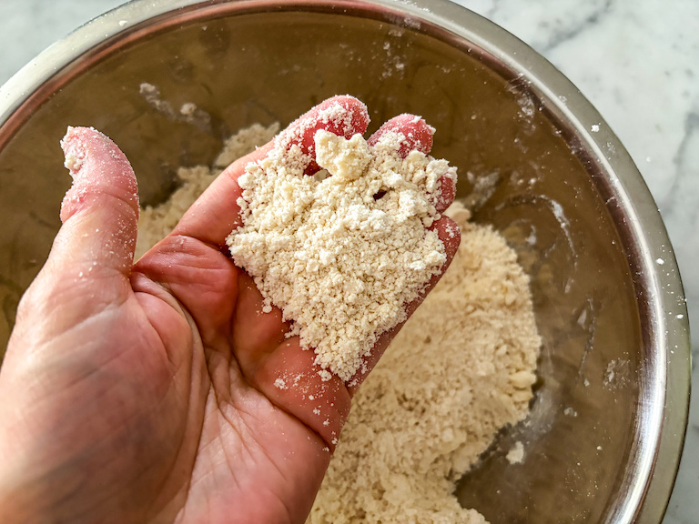 hand holding crumbled shortcrust pastry