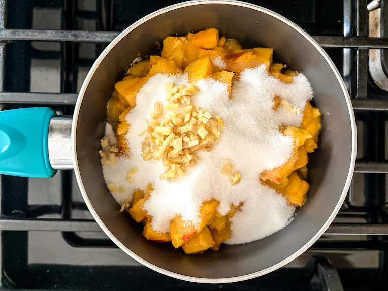peach jam ingredients in a small pan on the stovetop